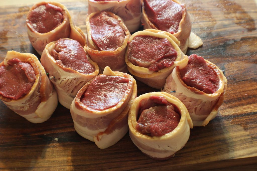 Wrap the steaks in a single thickness of bacon and secure with toothpicks or a bamboo skewer.